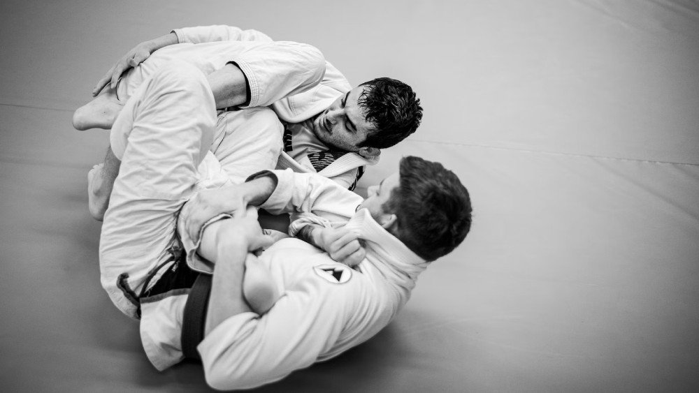 jovens fazendo rola de jiu-jitsu